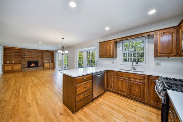 a large kitchen with stainless steel appliances granite countertop a large stove a sink dishwasher and a microwave oven with wooden floor
