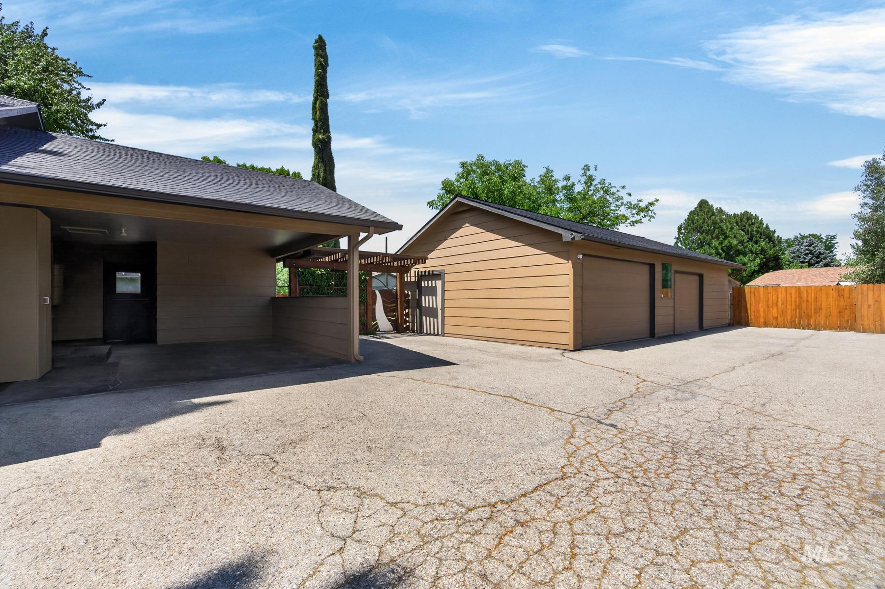 9622 Delaware Street Boise, ID 83709 - Photo 44 of 48 Expansive paved driveway leading to a detached two-car garage and a covered carport