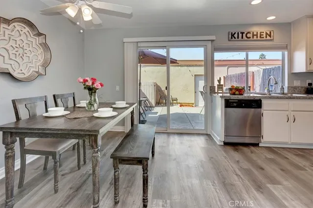 a dining room with wooden floor a chandelier a wooden table and chairs