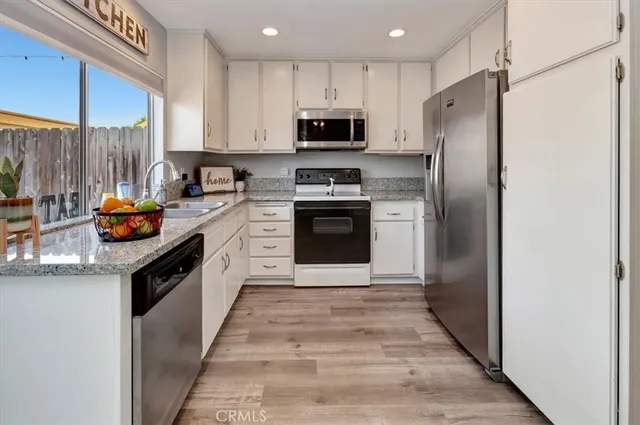 a kitchen with stainless steel appliances granite countertop a refrigerator stove and sink