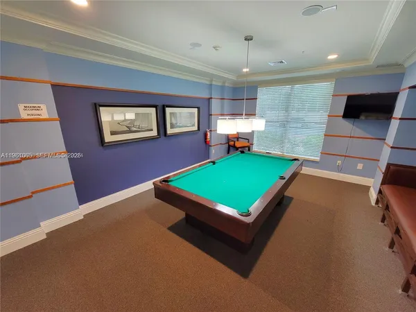 a room with pool table and windows