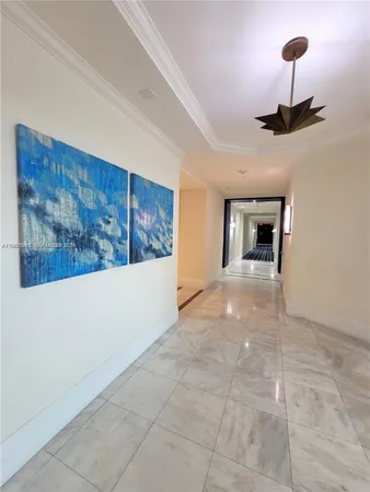 a view of an empty room and chandelier fan