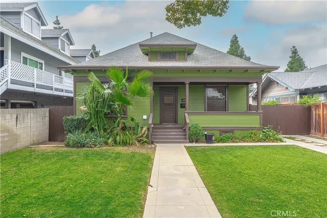 a front view of a house with a yard and potted plants