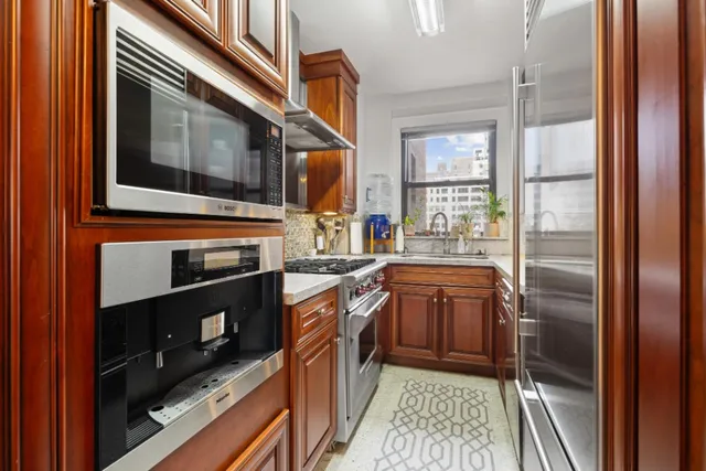 a kitchen with stainless steel appliances granite countertop a refrigerator and a stove top oven