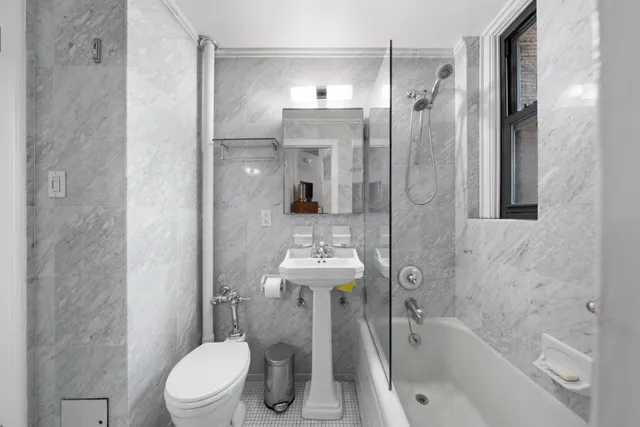 a bathroom with a bathtub shower sink mirror and toilet