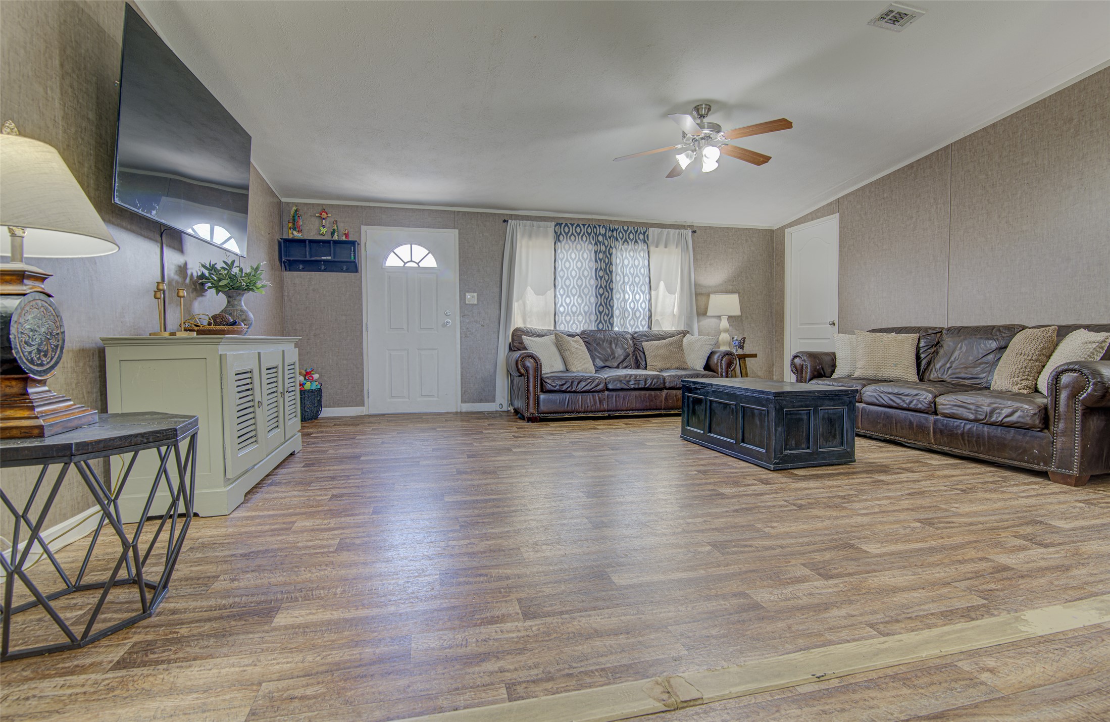 445 Rancho Linda Drive Lockhart, TX 78644 - Photo 10 of 26 Vinyl plank flooring and a classic ceiling fan enhance this comfortable living space.