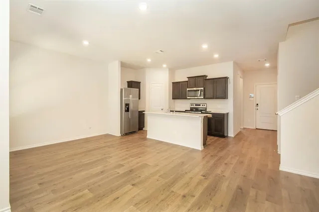 a view of kitchen with granite countertop cabinets and refrigerator