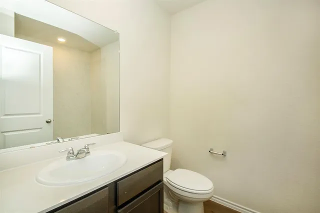 a bathroom with a sink a toilet and a mirror