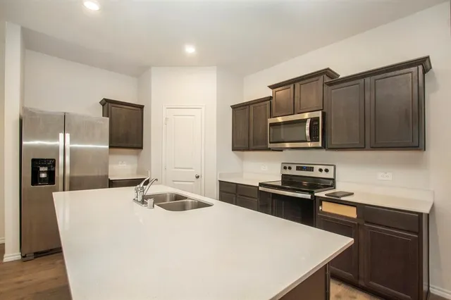 a kitchen with stainless steel appliances a sink microwave and refrigerator