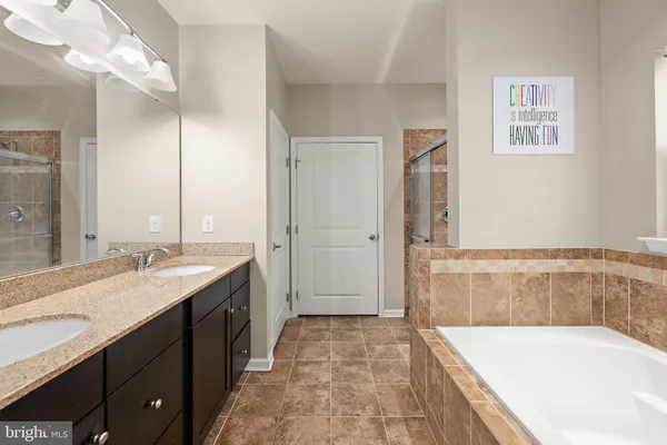 a bathroom with a tub a sink and a shower