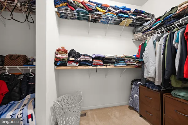 a view of walk in closet with clothes and shoes