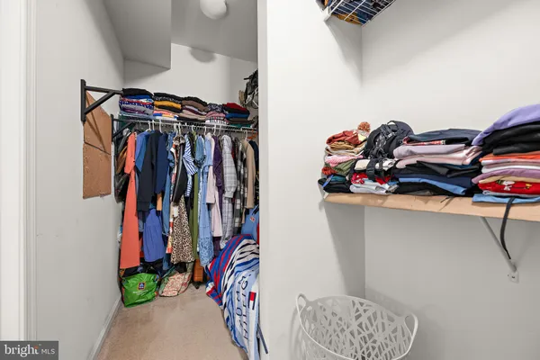 a view of walk in closet with clothes