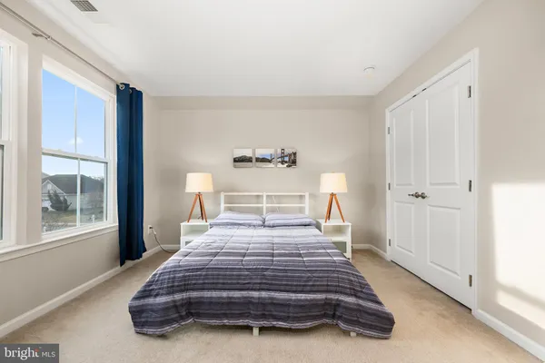 a spacious bedroom with a bed and large windows