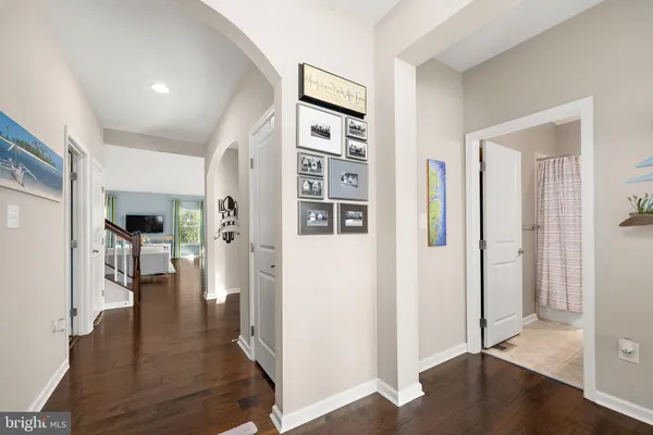 a view of a hallway with wooden floor and dining room