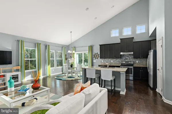 a dining room with furniture a large window and kitchen view