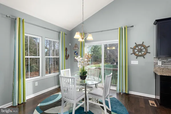 a dining room with furniture window and wooden floor