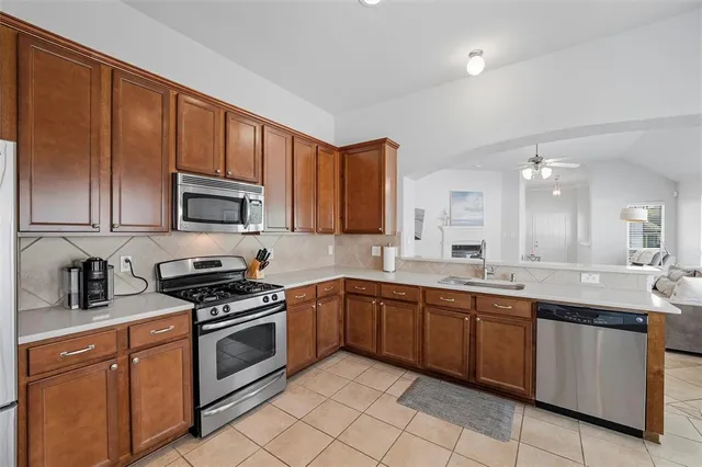 a kitchen with stainless steel appliances a sink cabinets and wooden floor