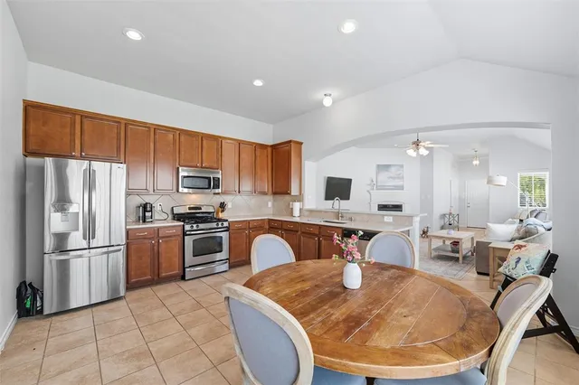 a kitchen with stainless steel appliances granite countertop a refrigerator a stove top oven a sink and dishwasher