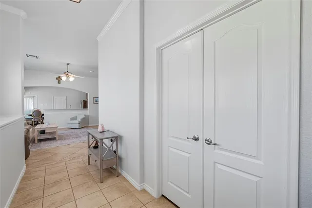 a view of a bedroom with wooden floor a ceiling fan and windows