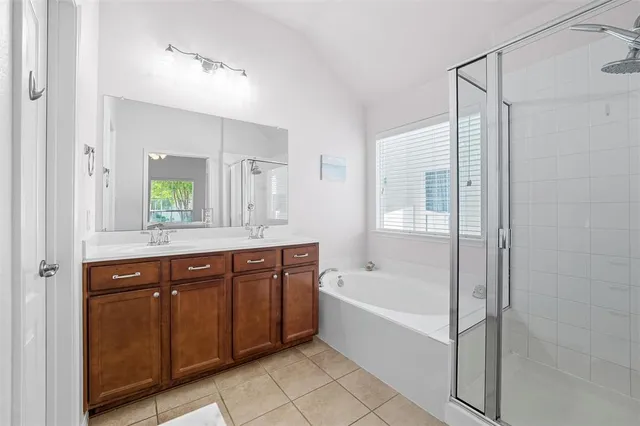 a bathroom with a bath tub a shower and a window