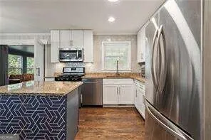a kitchen with stainless steel appliances granite countertop a refrigerator sink and stove