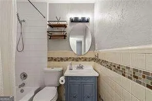 a bathroom with a granite countertop sink a toilet and shower