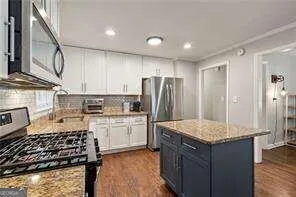 a kitchen with a refrigerator and a stove top oven