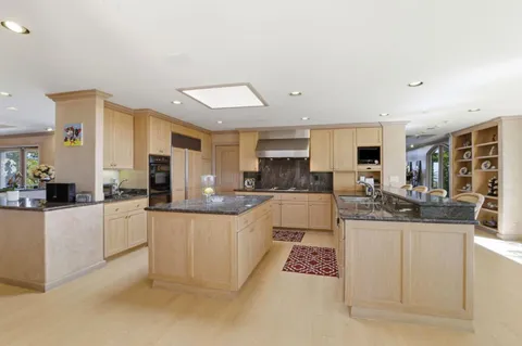 a kitchen with stainless steel appliances kitchen island granite countertop a sink and cabinets