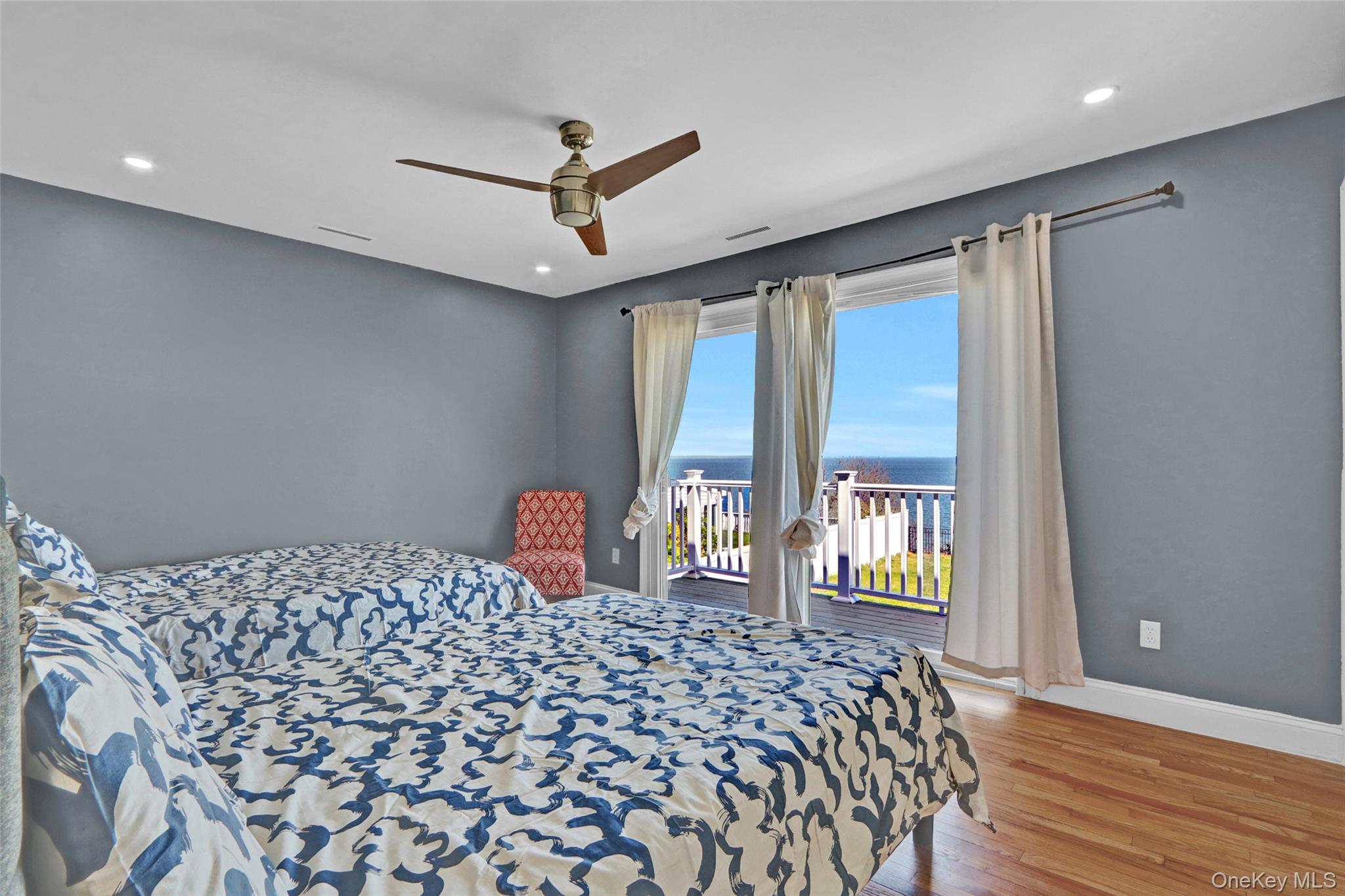 25 Wildwood Road Rocky Point, NY 11778 - Photo 33 of 47 Bedroom 3 featuring a water view, wood finished floors, access to exterior, a ceiling fan, and recessed lighting
