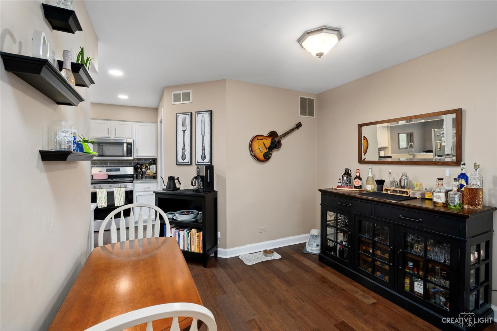 1180 Coldspring Road Elgin, IL 60120 - Photo 8 of 18 a kitchen with stainless steel appliances granite countertop a stove top oven a sink a dining table and chairs with wooden floor