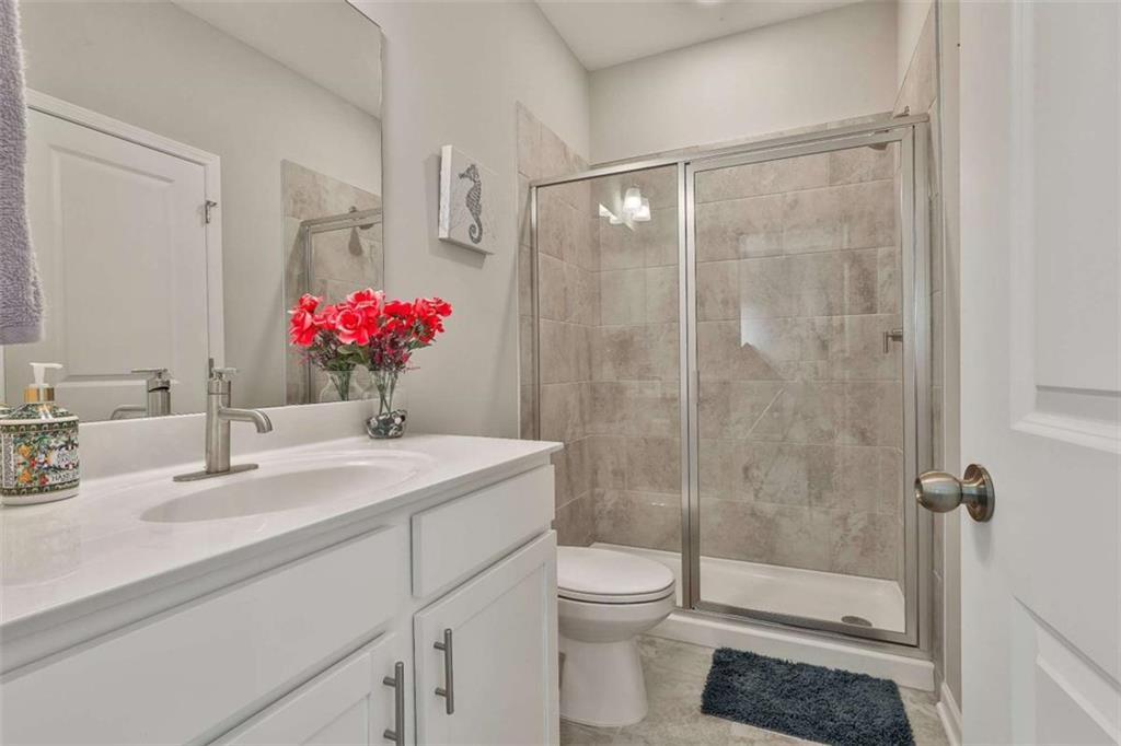 8 Unbridled Way Newnan, GA 30263 - Photo 11 of 49 a bathroom with a sink vanity granite toilet and a shower