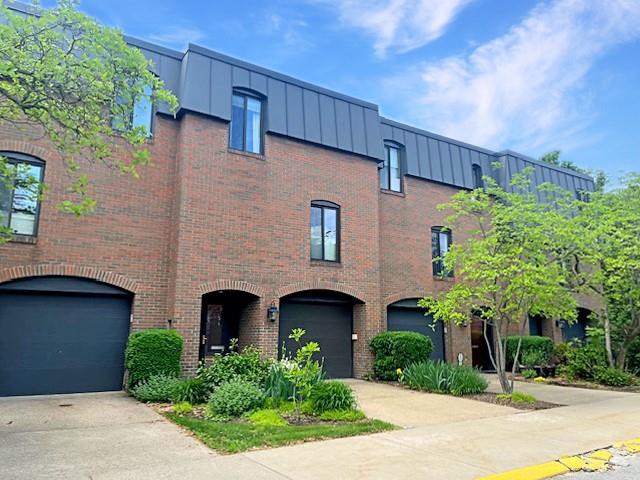 a front view of a house with plants and garage
