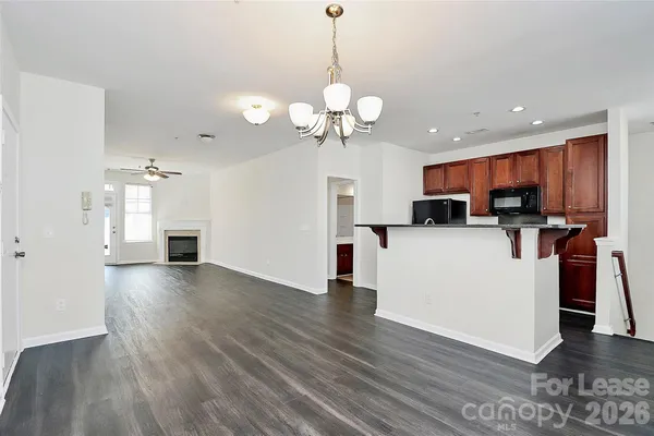 a view of a kitchen with a sink dishwasher a kitchen view with wooden floor and cabinets
