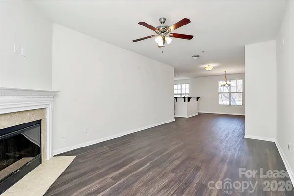 an empty room with wooden floor a fireplace and window