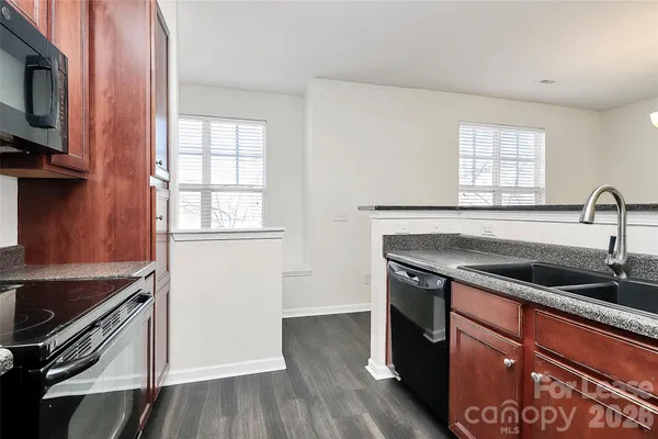 a kitchen with granite countertop a sink stove and cabinets