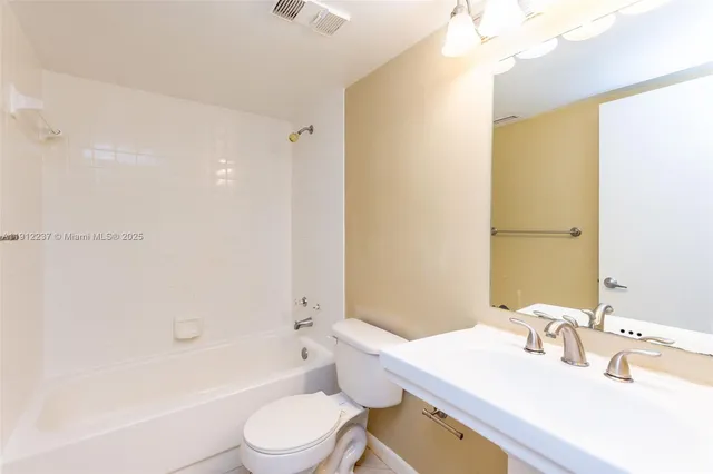 a bathroom with a sink a toilet a mirror and shower