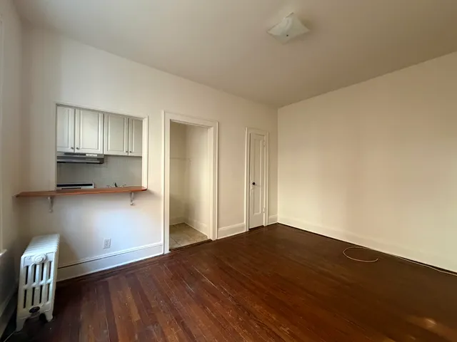a view of empty room with wooden floor
