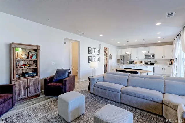 a living room with furniture kitchen view and a window