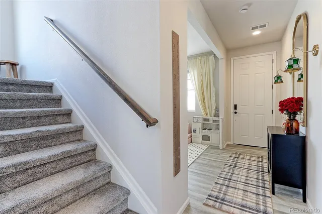 a view of a hallway with stairs and wooden floor