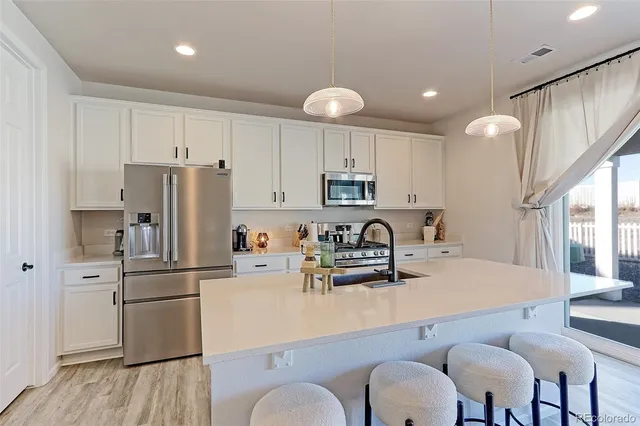 a kitchen with refrigerator cabinets and wooden floor