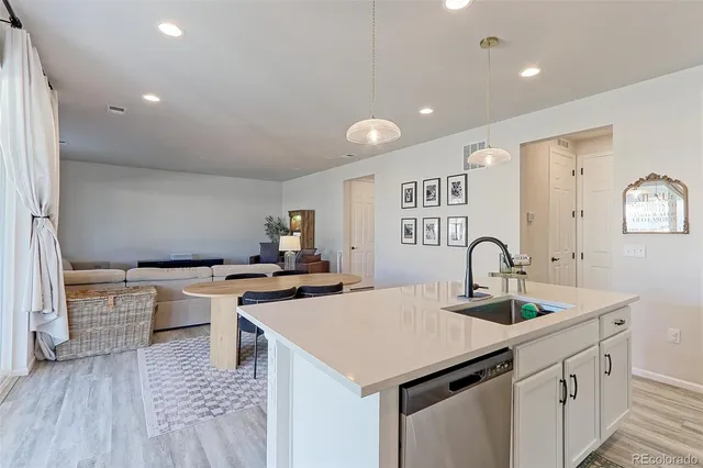 a kitchen with stainless steel appliances a sink a stove a refrigerator and cabinets