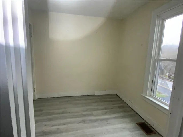 a view of a room that has wooden floor and windows