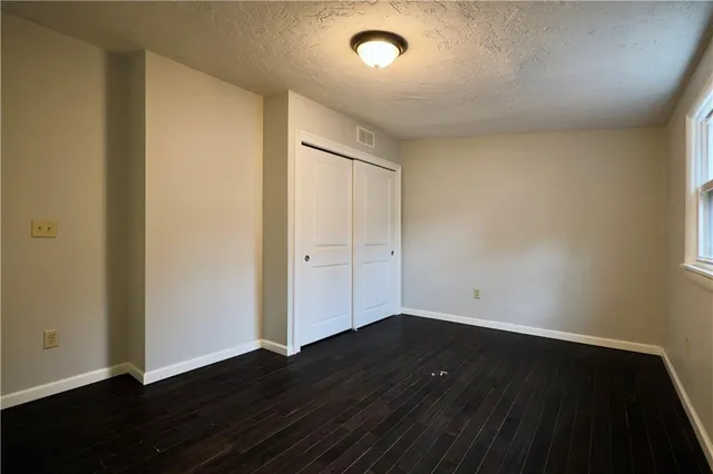 an empty room with wooden floor and cabinet