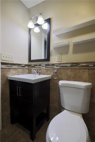 a bathroom with a toilet sink and mirror