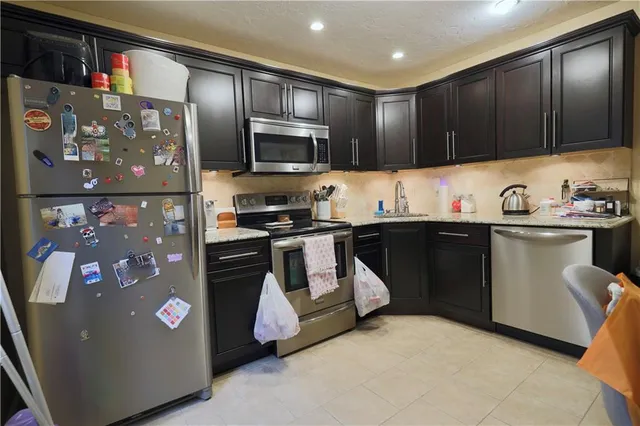 a kitchen with stainless steel appliances a refrigerator sink and microwave