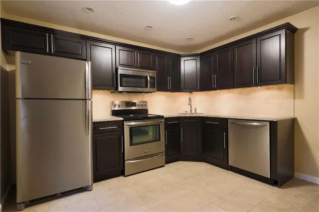 a kitchen with granite countertop stainless steel appliances and refrigerator