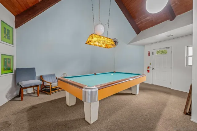 a room with pool table and windows
