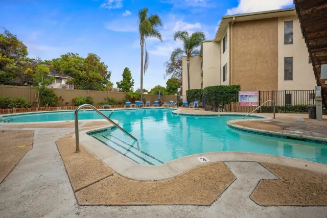 a view of a swimming pool with a yard and plants