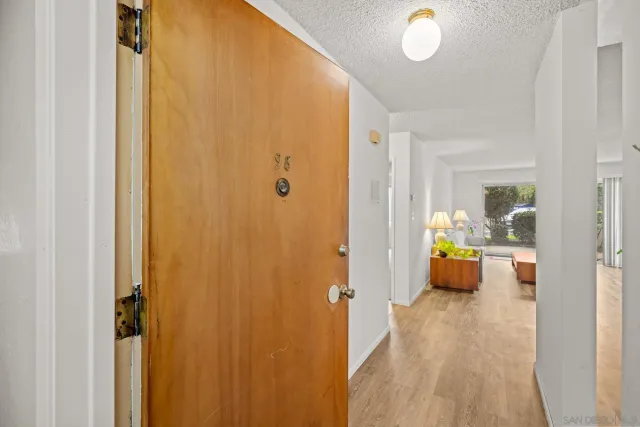 a view of a hallway with dining room and wooden floor