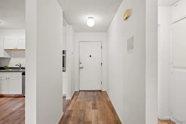 a view of a hallway with wooden floor and closet